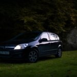 a small black car parked in a grassy field